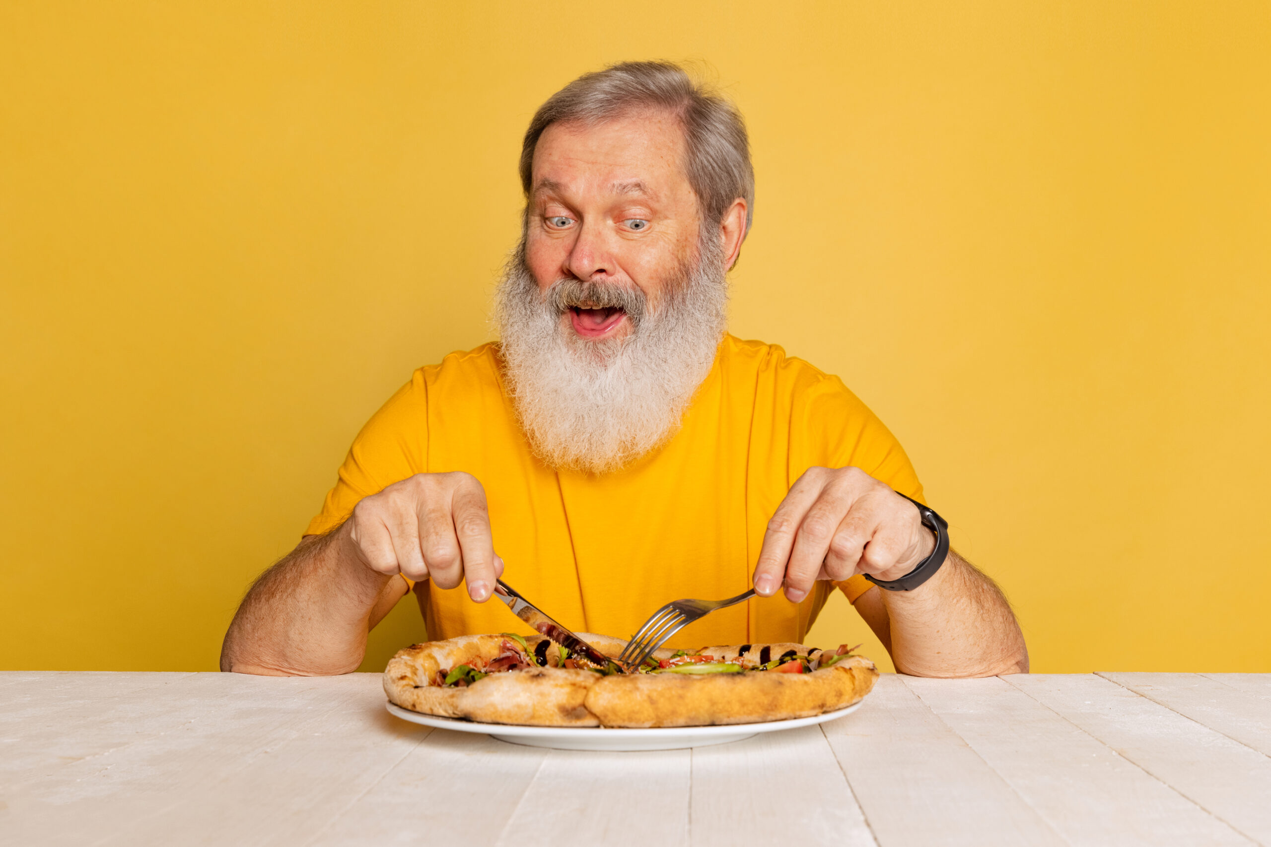 Willa Seniora w Buczkowicach - portrait senior man eating delicious italian isolated yellow studio background 1 scaled